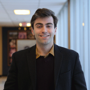 Nathan Rickey smiling in a hallway