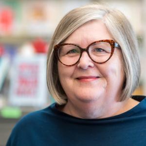 Rebecca Luce-Kapler smiling in the library