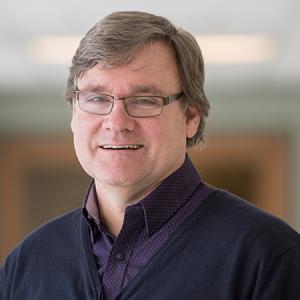 Richard Reeve smiling in the hallway