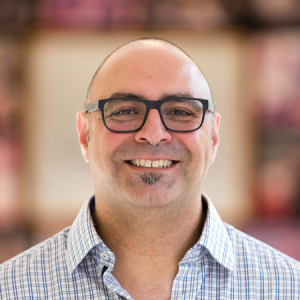 Saad Chanine smiling in a hallway with glasses on