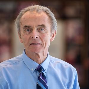 Tom Russell looking at the camera in a hallway