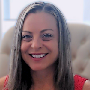 Jessica smiles at the camera. She has long dark blond hair and is wearing a silver heart necklace and a red shirt