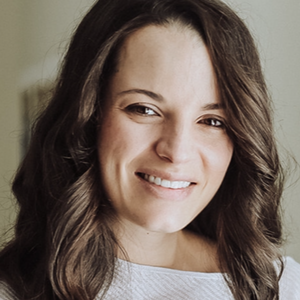 Jessica Rich smiles in a white top against a grey background.