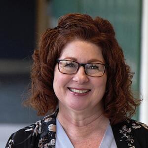 Lisa Tugnette smiles in a hallway.