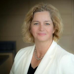 Heather Morrison smiles in a white blazer.