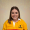 Kylie Rafter smiles inside in a striped Queen's rugby shirt.