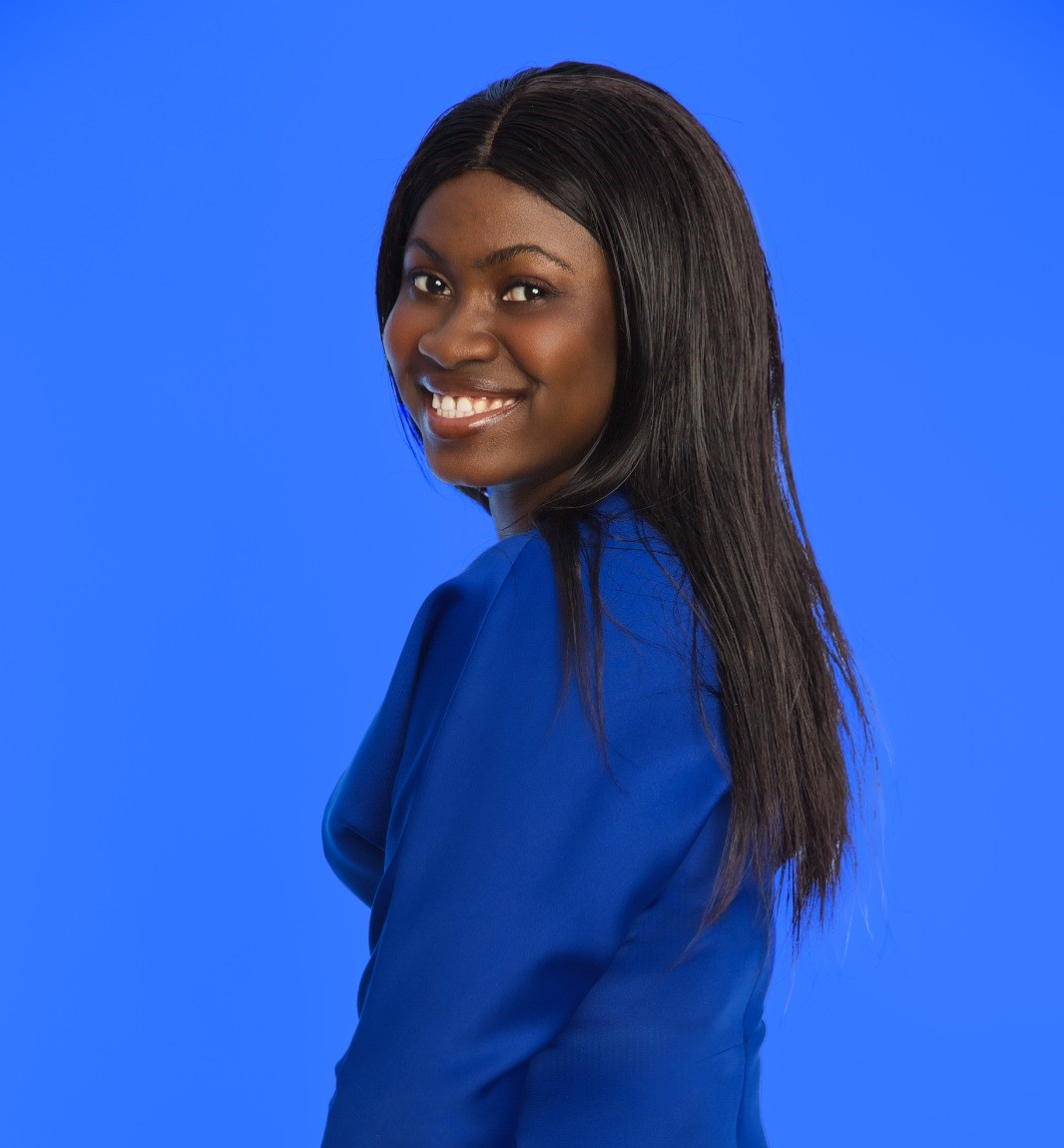 Ann smiles at the camera wearing a blue dress