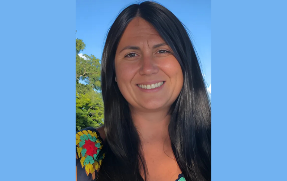 Jennifer Fraser smiles wearing a colourful shirt outside. There are two blue bars surrounding the image.