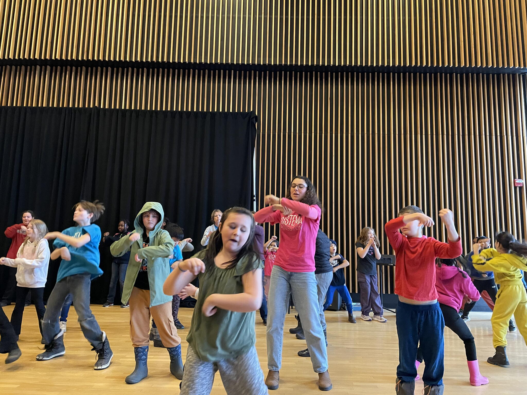 Olivia White practicing a dance with Sistema students 