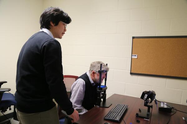 faculty member demonstrates the eye tracking equipment 