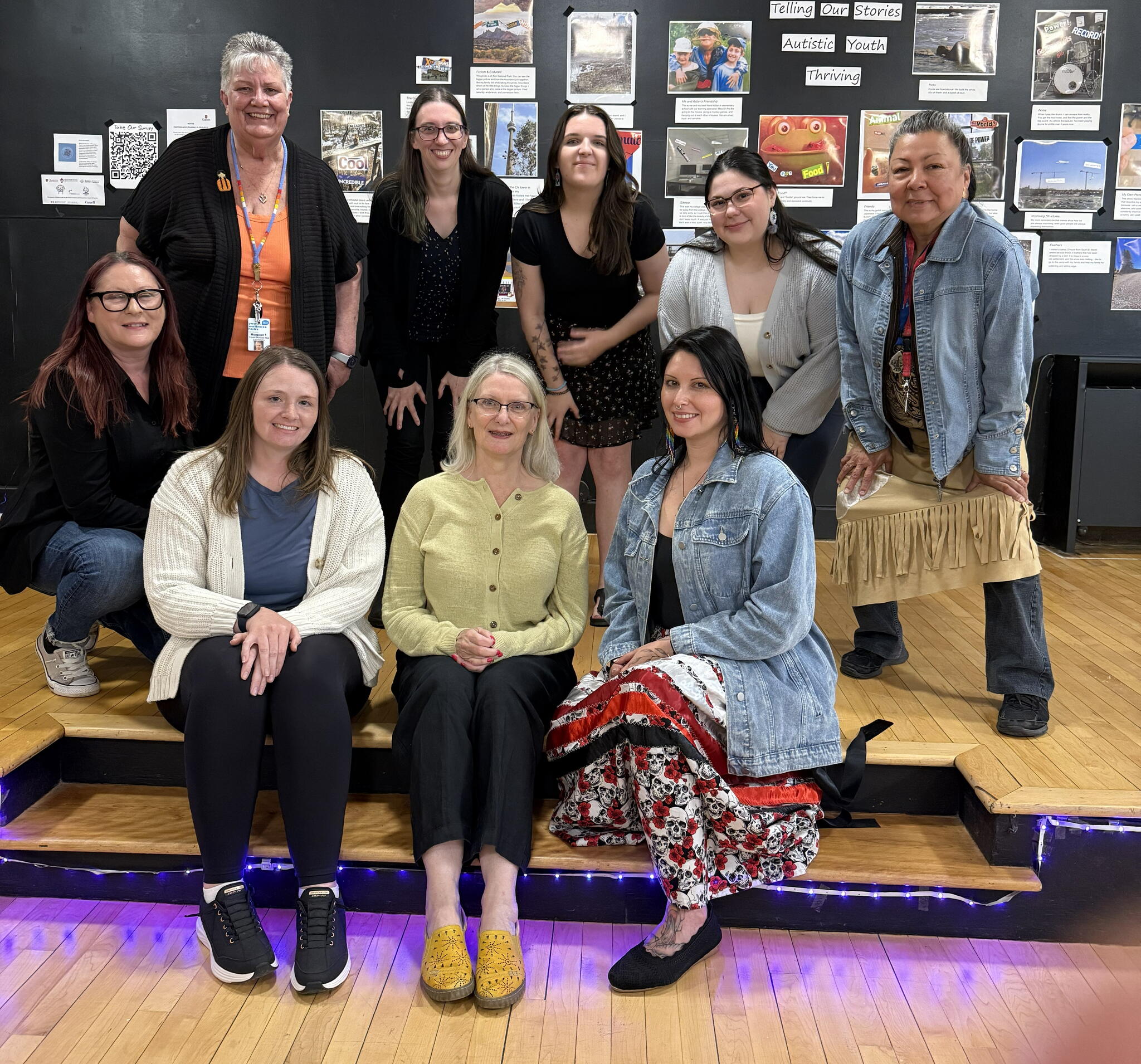 a group of people smiling at the camera, all present as women