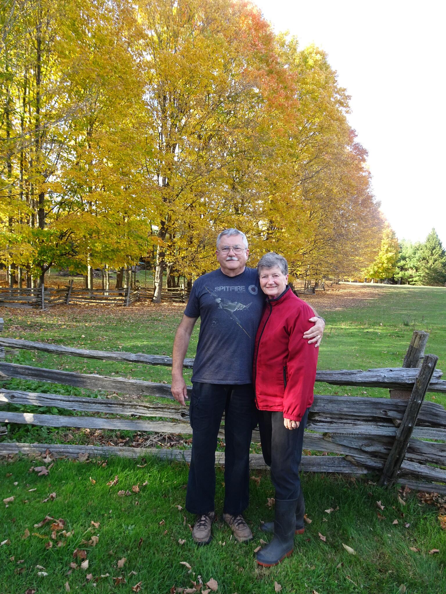 John and Donna smile in a photo from 2025 standing outside wearing outdoor clothing.