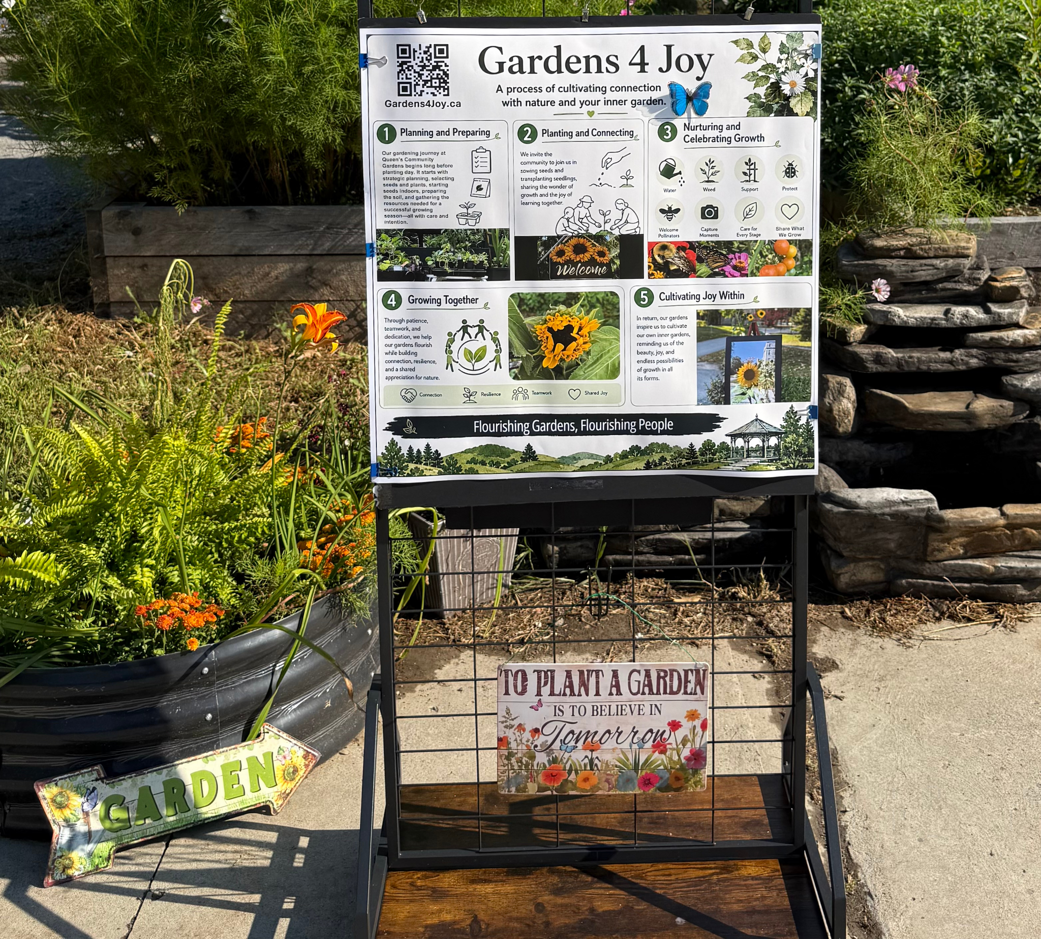 A poster that reads "Gardens 4 Joy, flourishing gardens, flourishing people" shows small text detailing the process of planting the garden. The text is too small to read.