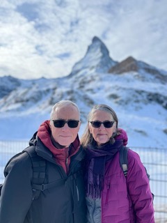 Maureen Watkin with partner in winter apparel standing in front of a snowy mountain.