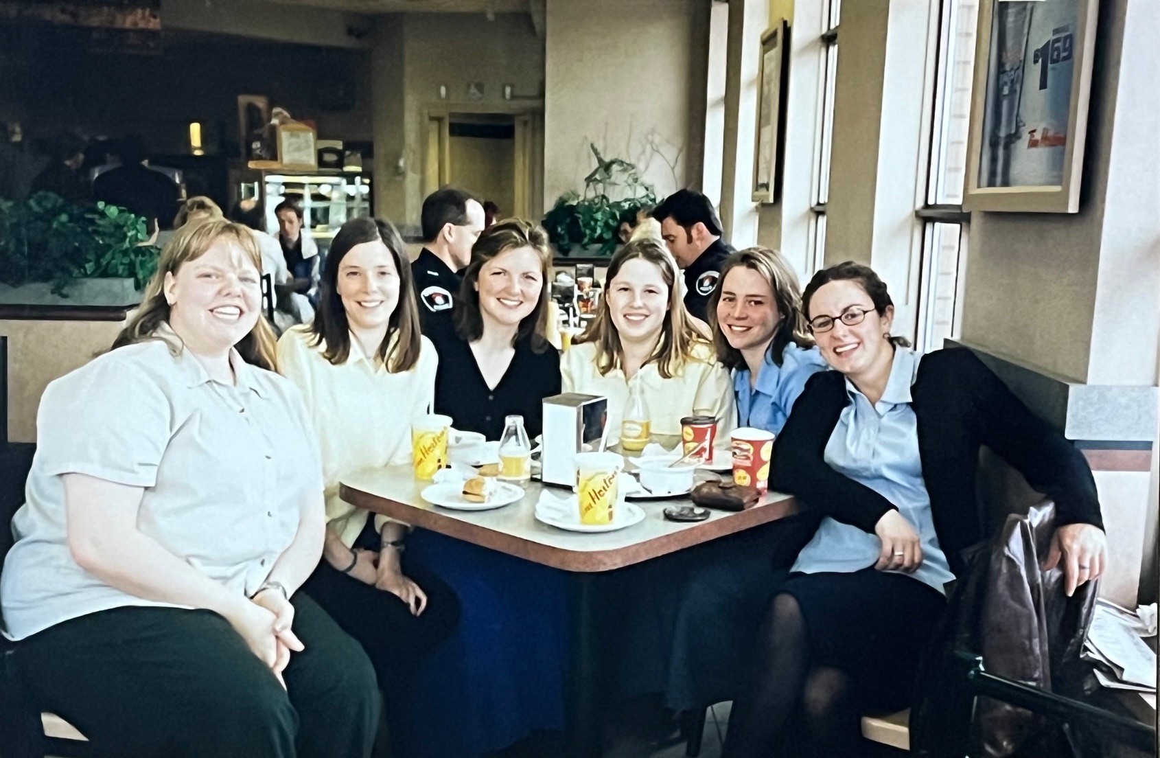 Students pose at a table in a coffee shop.