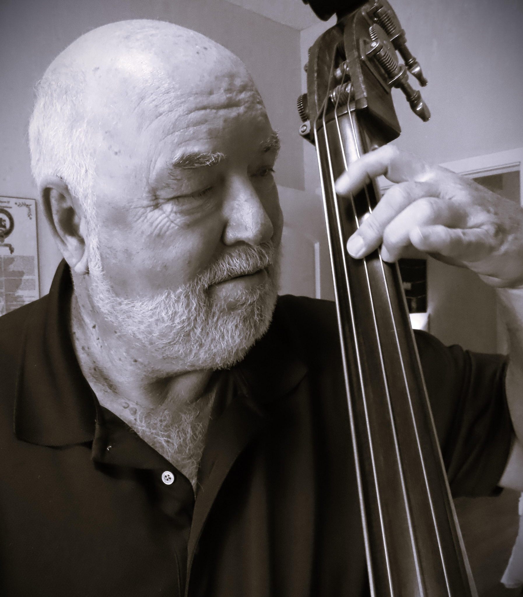 Roger Finlay plays a cello and looks towards his fingers which are places on the instrument.