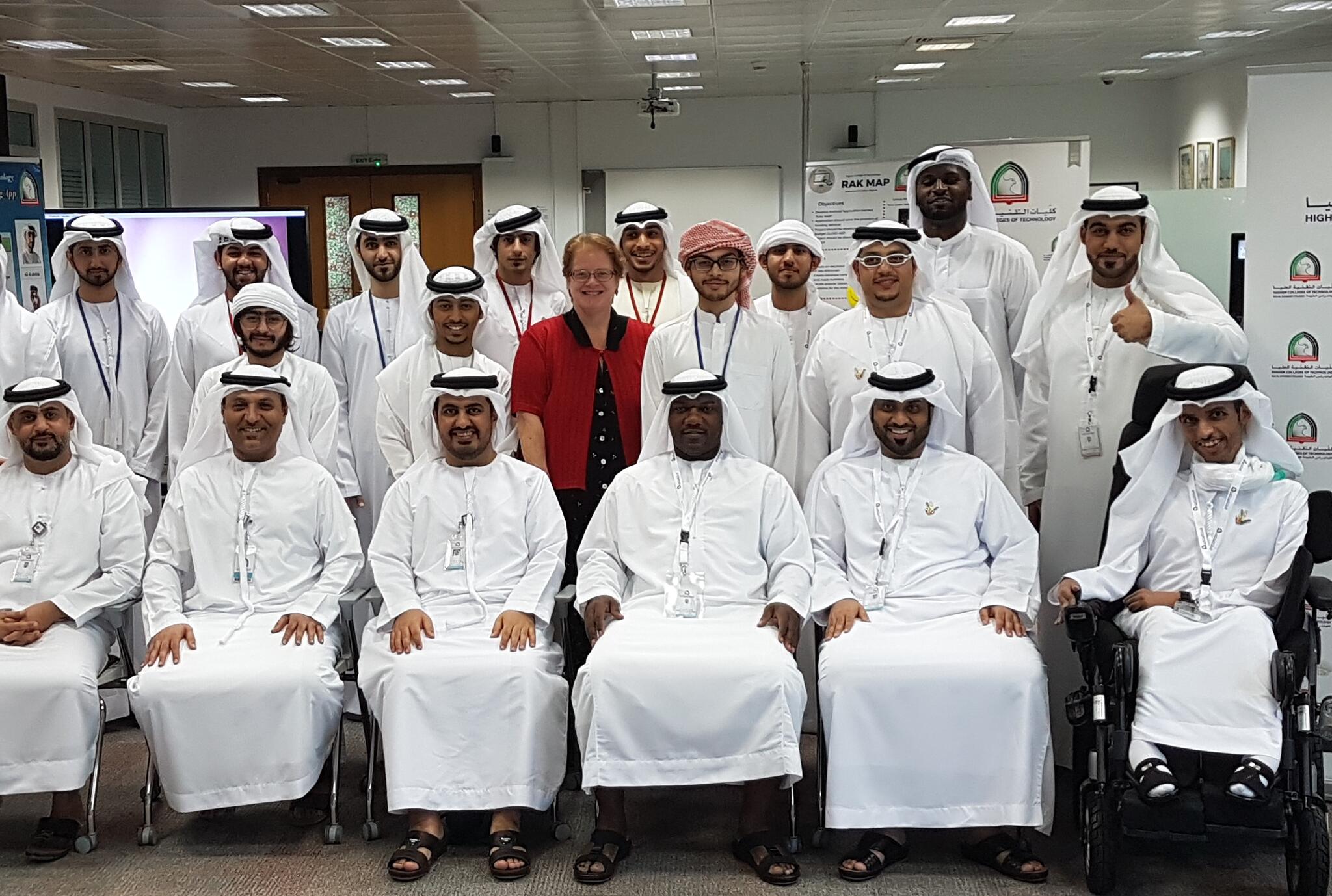 Sheri Henderson stands at the centre of a group of teachers wearing white robes and head scarves.