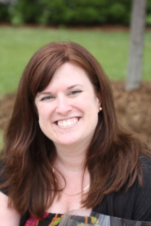 Kim Hutchinson Lewis smiles outside.