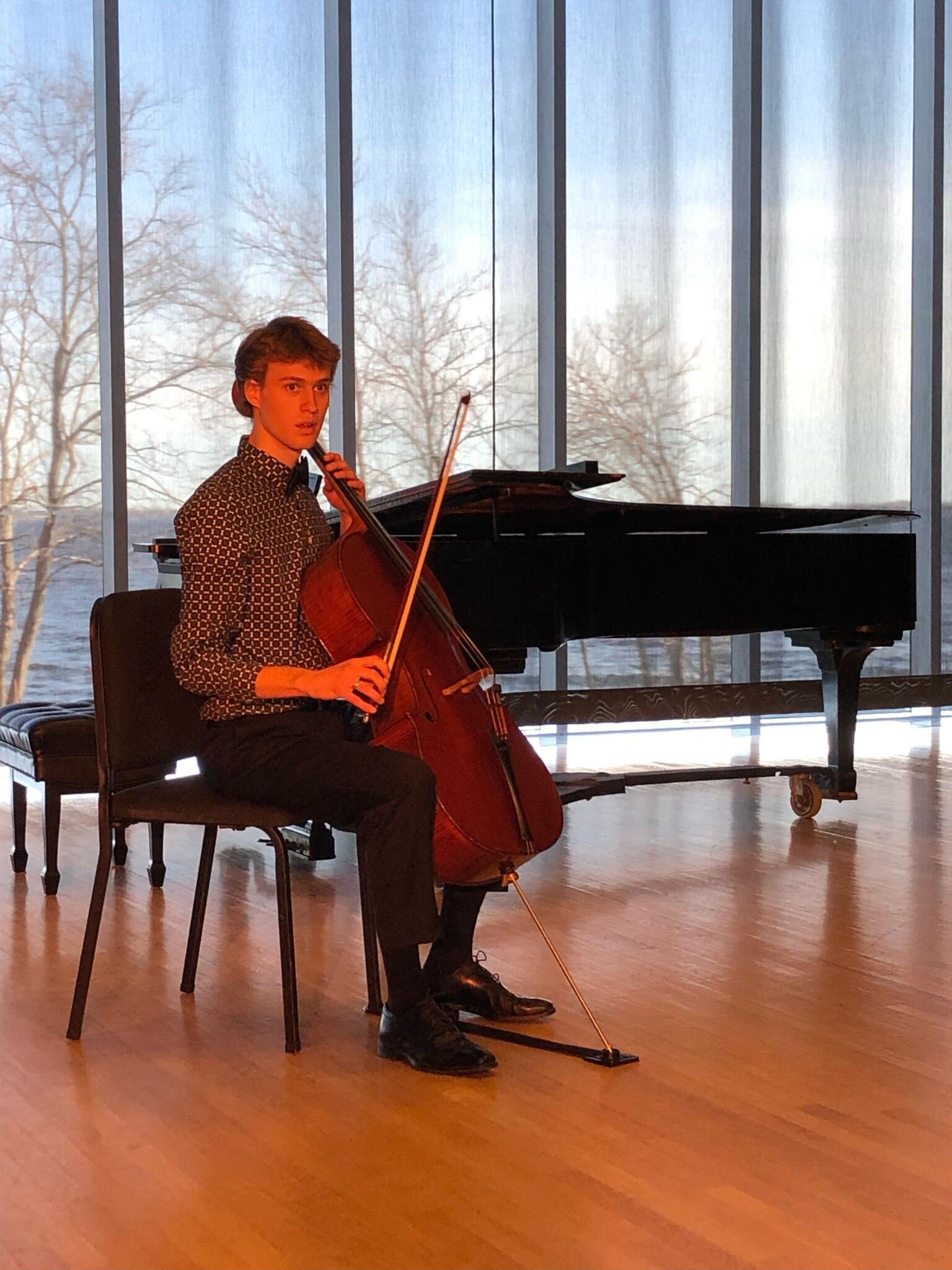 Will Smythe sits with a cello.