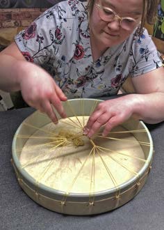 Portia stringing one of her handmade hand drums in her studio.