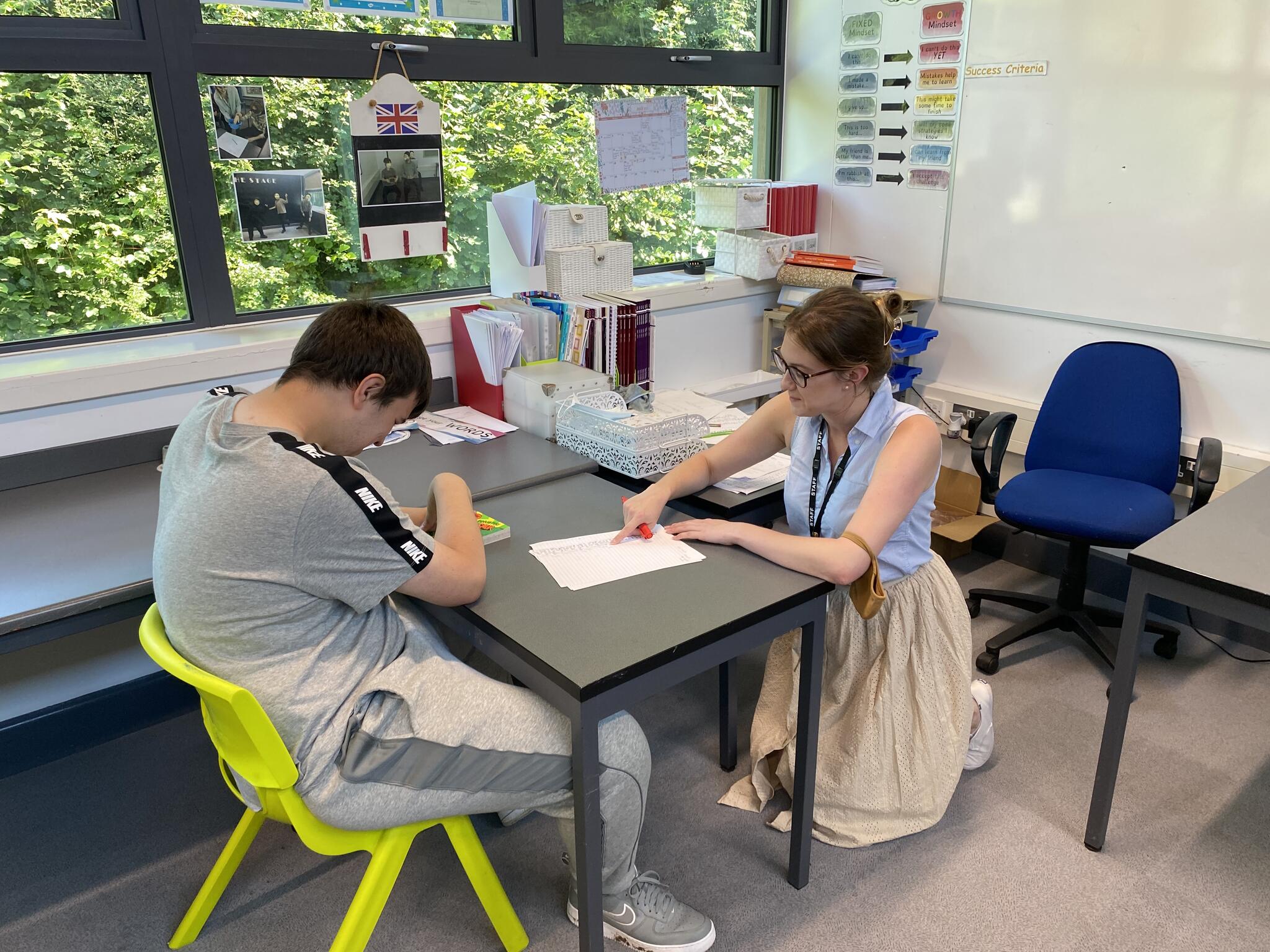 Shelby and Student working in a classroom 