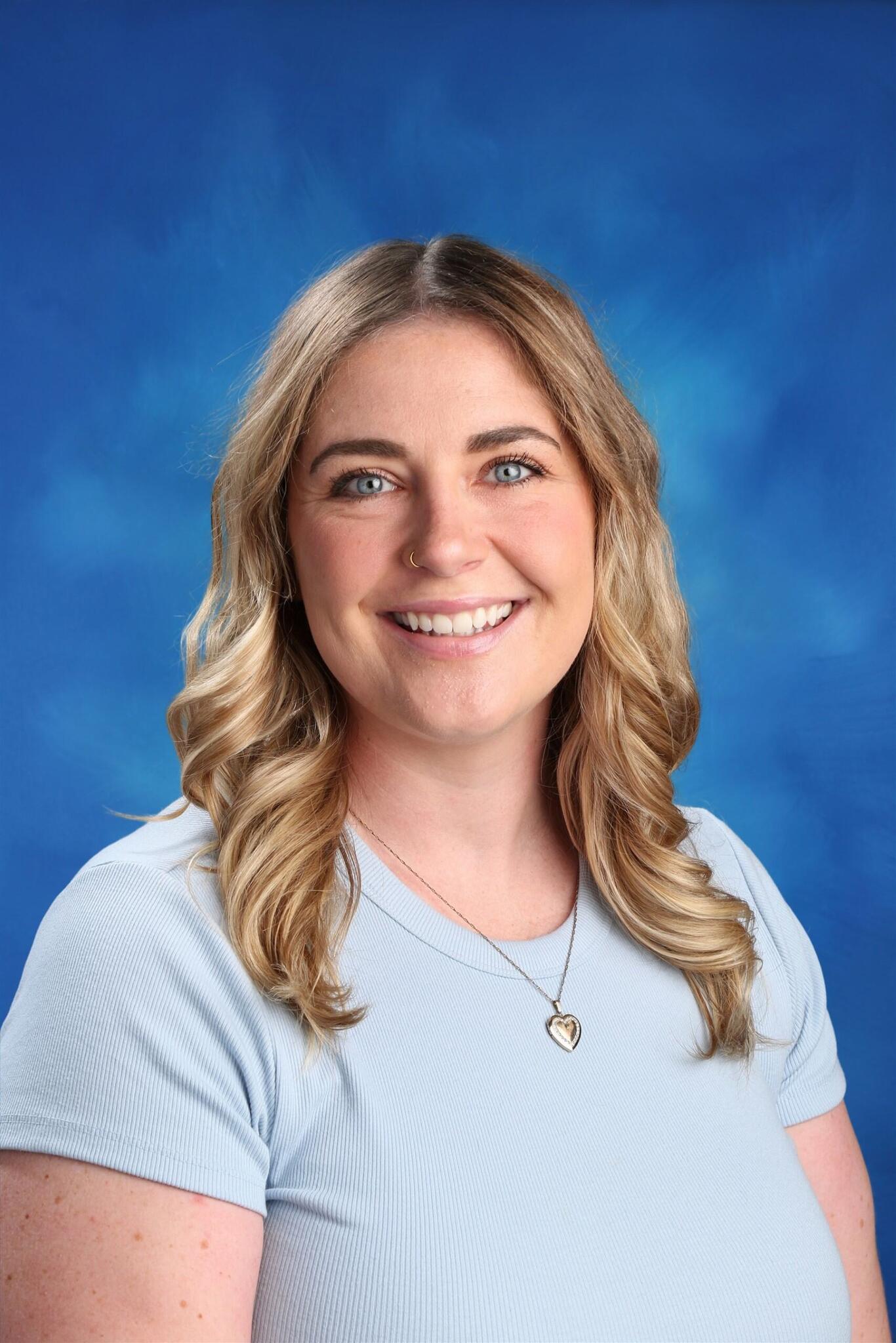 A white blond woman takes a school photo