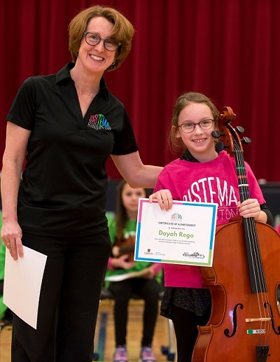 Karma Tomm, Sistema Kingston Director, poses with Dayah Rego at the Paper to Wood Ceremony