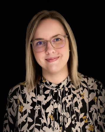 Tiina Kukkonen smiles wearing a floral shirt against a black background.