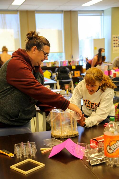 Two students set up a class project to present in front of their peers.