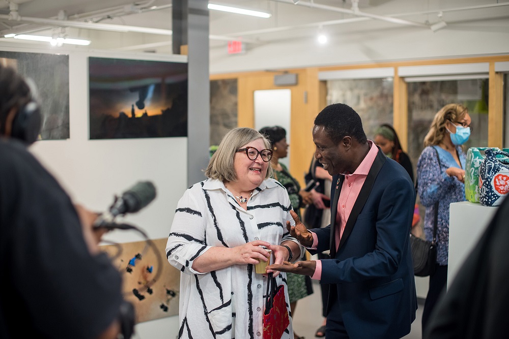 Rebecca Luce-Kapler talks with Hakeem Subair in an art gallery.