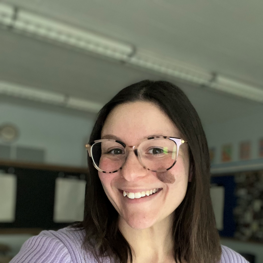 Nicole Tsitsopoulos smiles wearing glasses and a purple shirt.