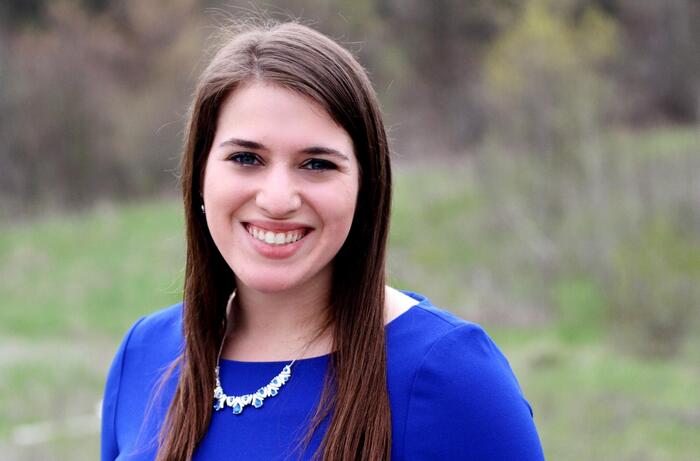 Jodi Basch smiles outside in a bright blue shirt.