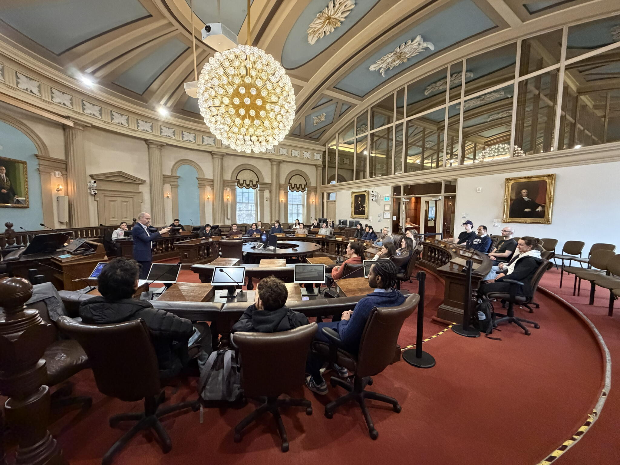 A room inside city hall with the mayor and people around him 