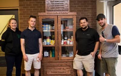 Queen's Community Cupboard with students who built it